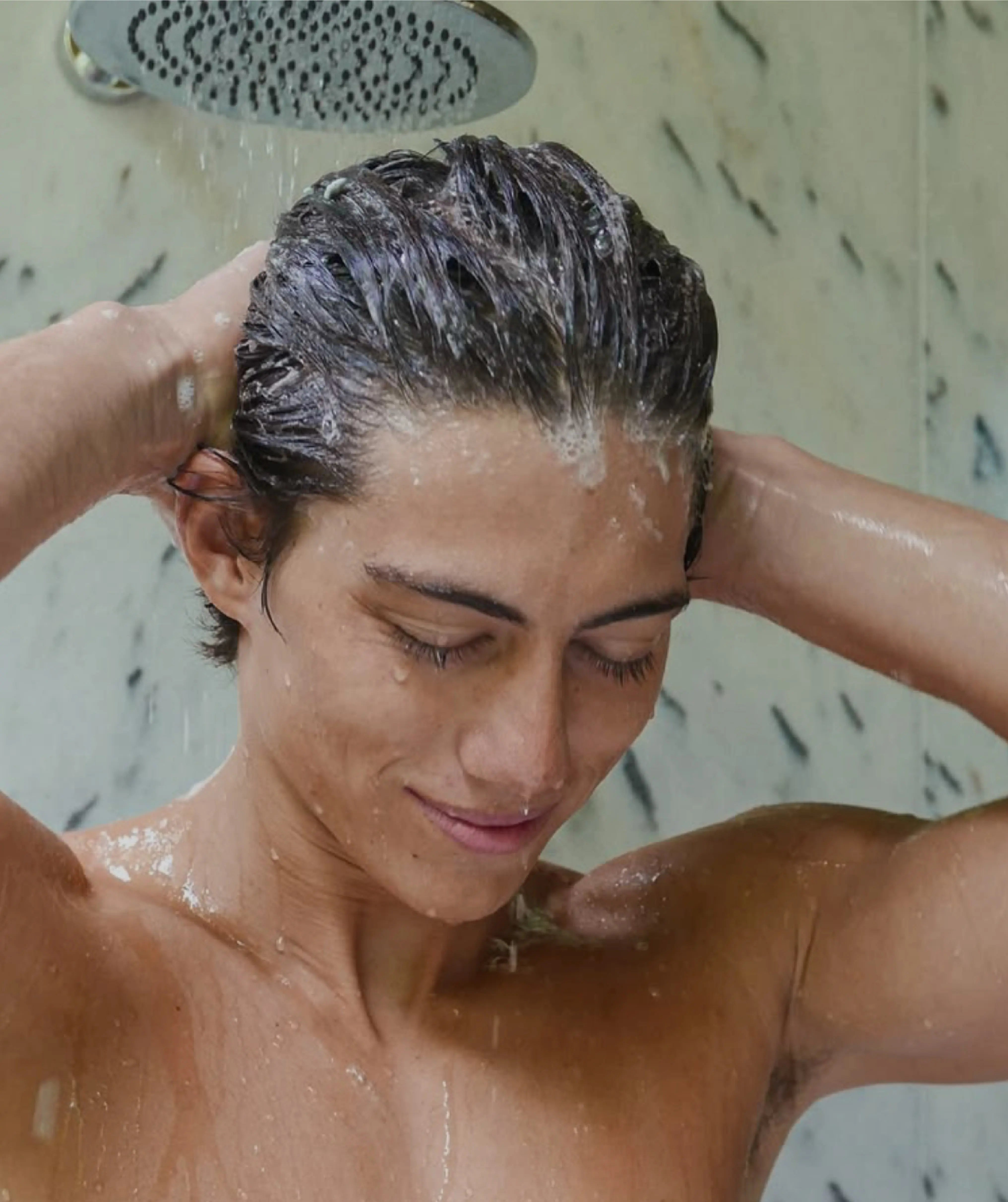 Man washing his dark brown hair in the shower