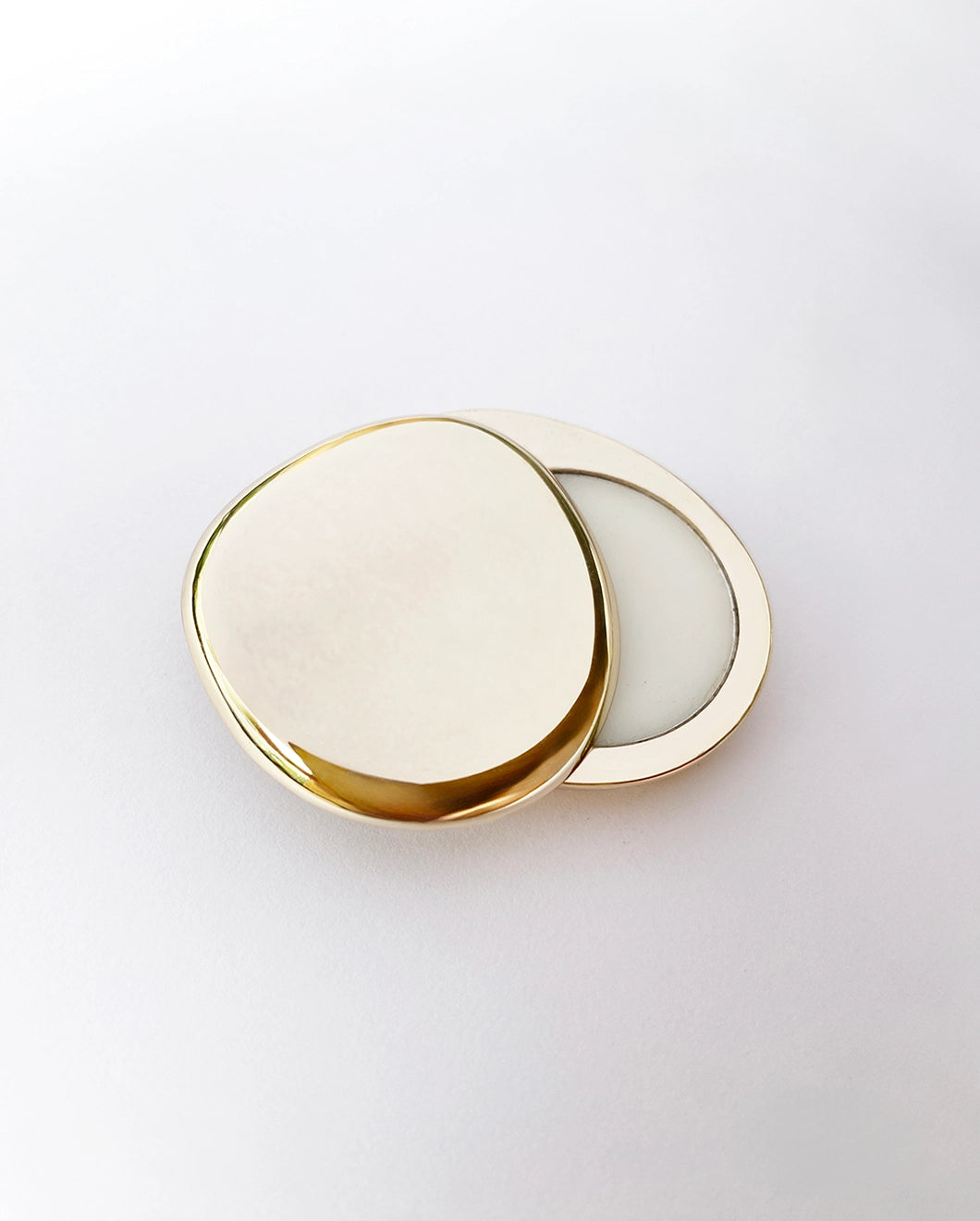 Juniper Dawn Solid Scent by Blu & Green. Gold, pebble-like case.