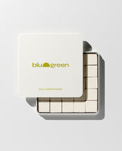 Load image into Gallery viewer, blu and green daily conditioner 50 cream-colored square tablets in a flat square tin with green-yellow logo. lid slightly off, studio, white ground, and strong light.