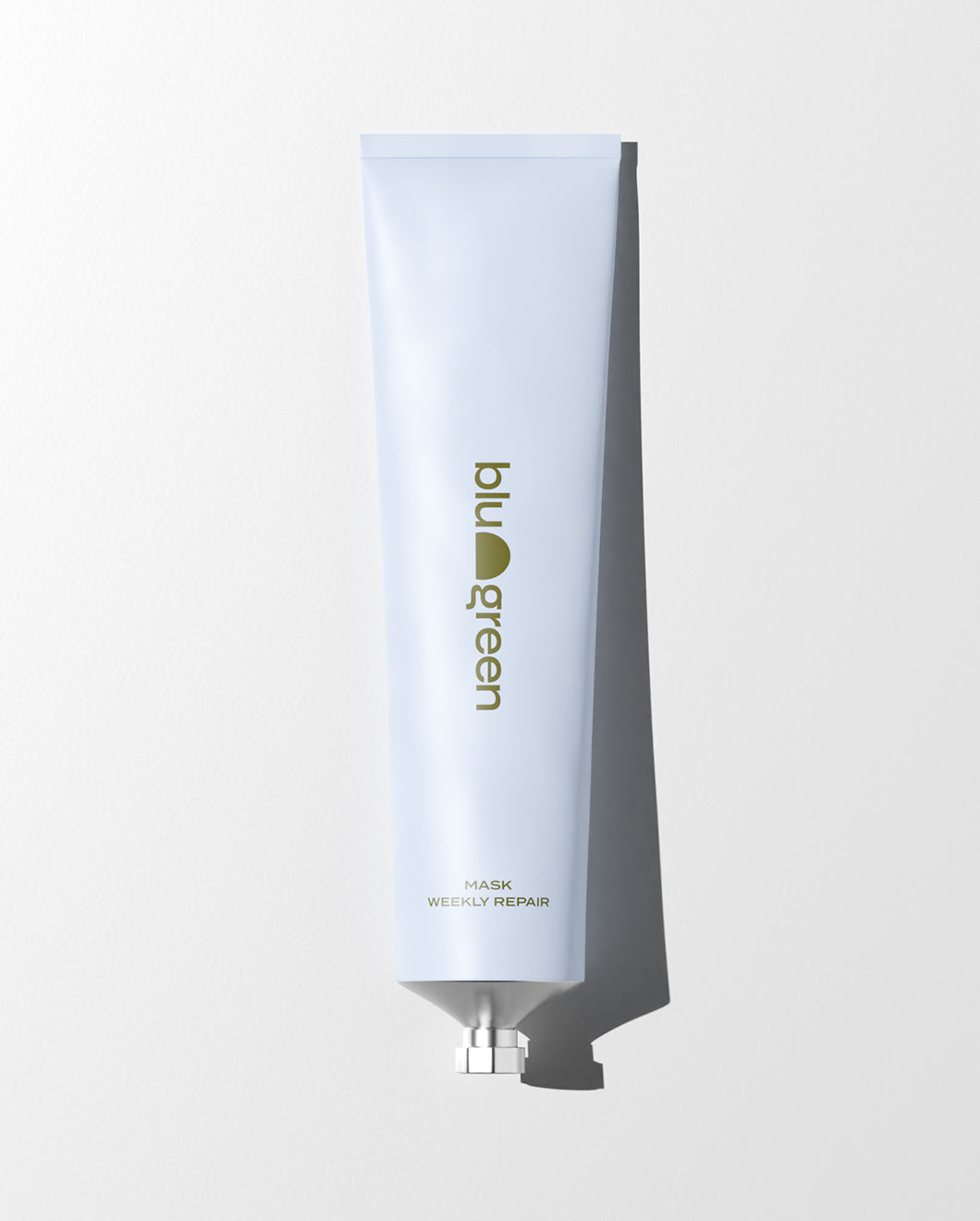 blu and green weekly repair mask 150ml aluminum tube pale blue with dark green logo laying flat, white ground, and strong light.