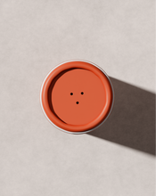 Load image into Gallery viewer, Close-up of Blu & Green Dry Shampoo orange shaker cap with three dispensing holes, eco-friendly aerosol-free powder.