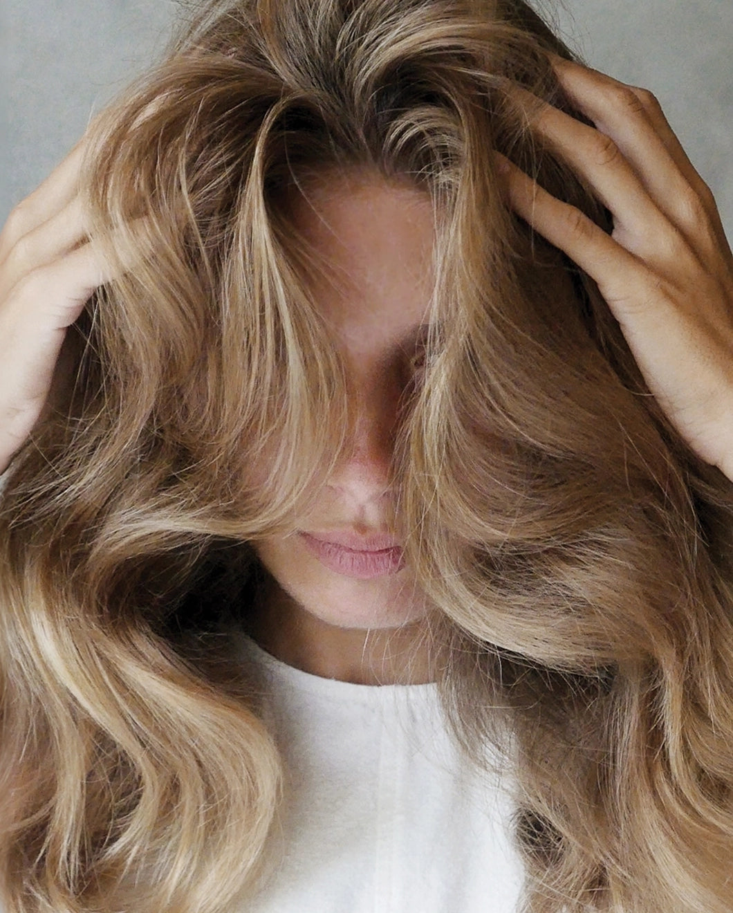 Close-up of woman with long, voluminous hair framing her face.