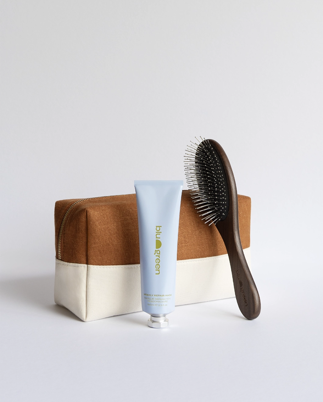 Blu & Green's Holiday Repair kit, including the Weekly Repair Mask, Walnut Detangling Brush, and a complimentary canvas bag.