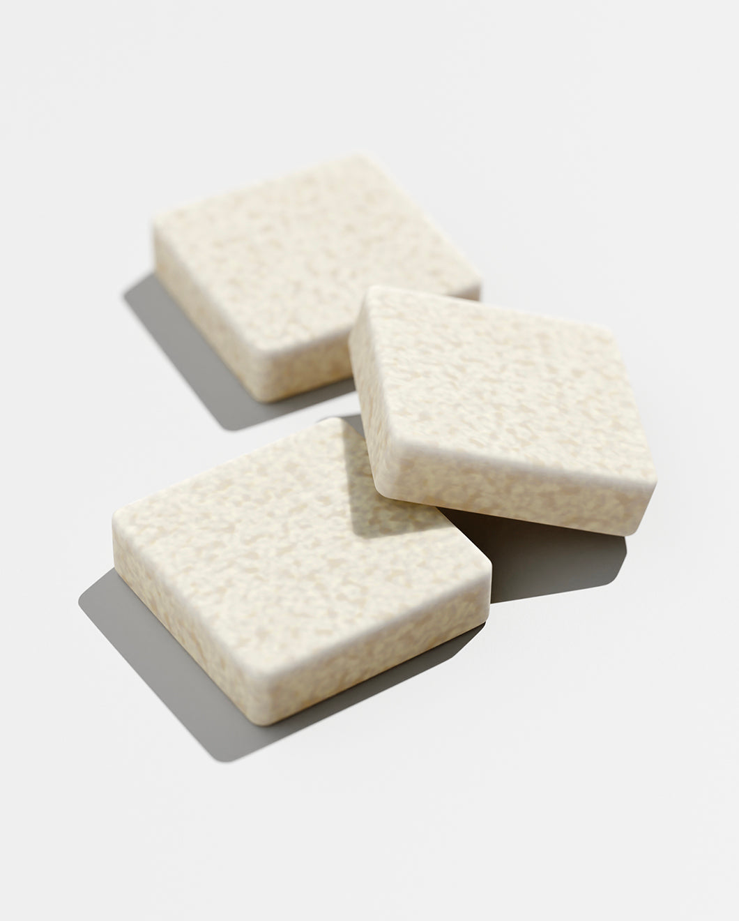 blu and green daily conditioner square tablets, studio, white ground, and strong light.