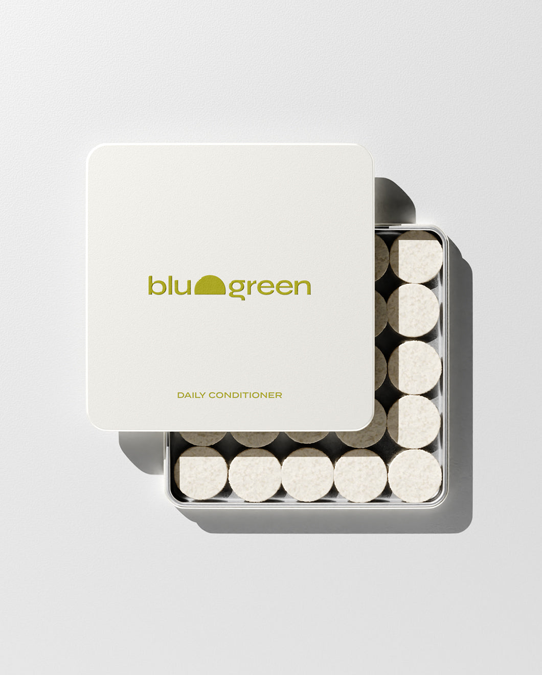 blu and green daily conditioner 50 cream-colored tablets in a flat square tin with green-yellow logo. lid slightly off, studio, white ground, and strong light.