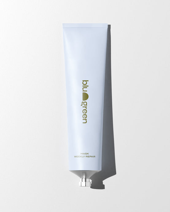 blu and green weekly repair mask 150ml aluminum tube pale blue with dark green logo laying flat, white ground, and strong light. 