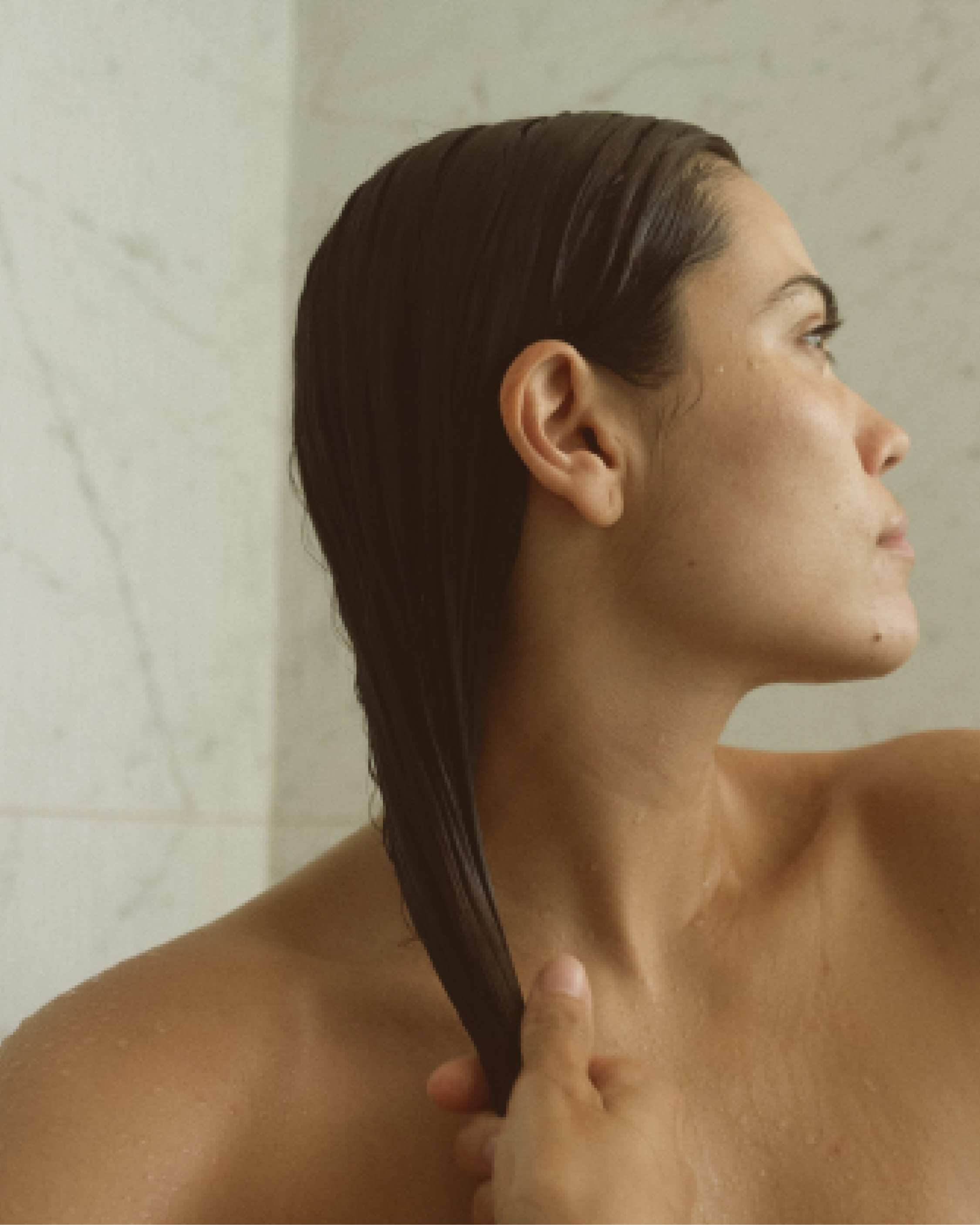 Woman applying Blu & Green Daily Conditioner Concentrate in the shower after cleansing.