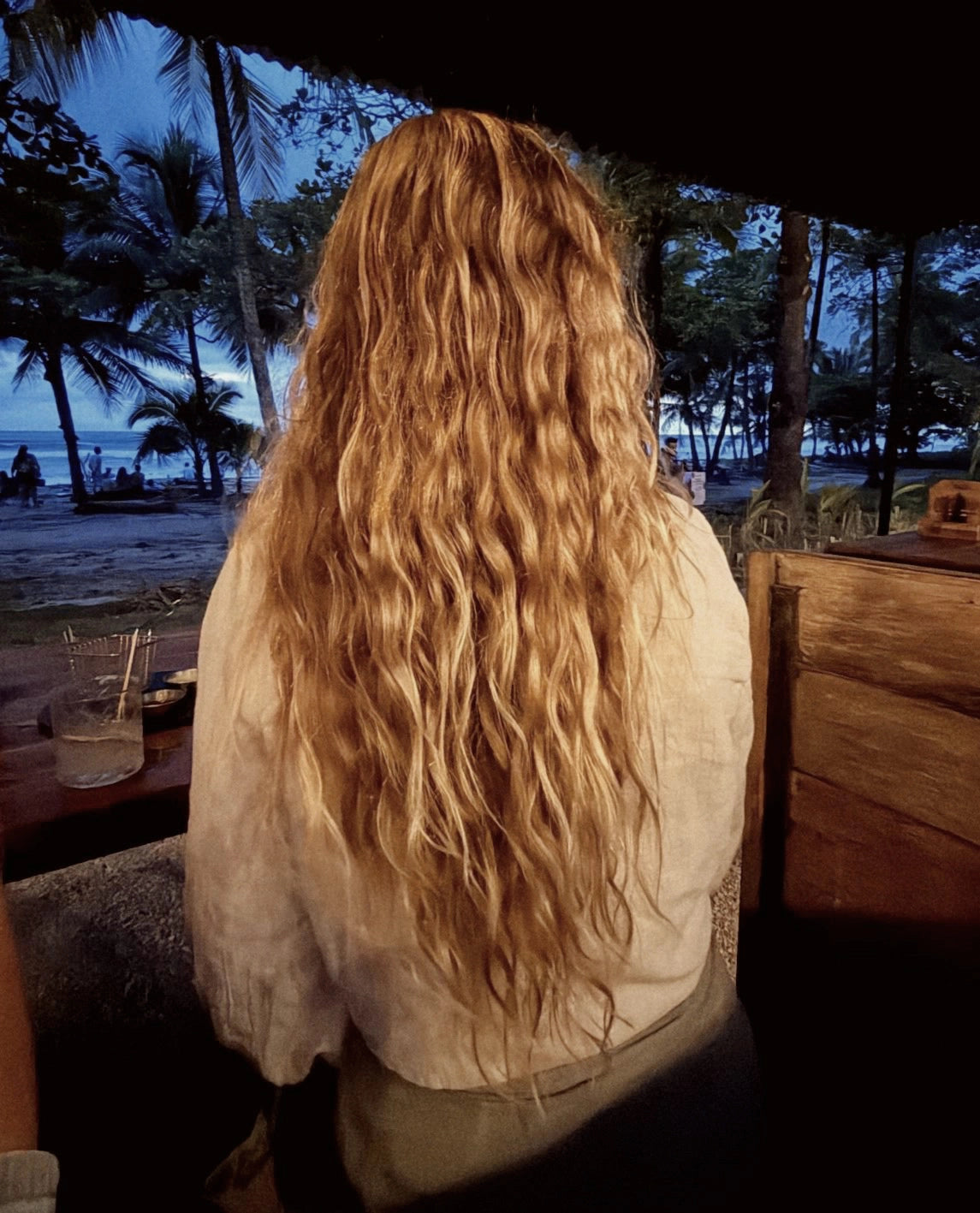 Back view of woman with long, wavy hair, showcasing her results from using the Blu & Green Weekly Repair Mask.