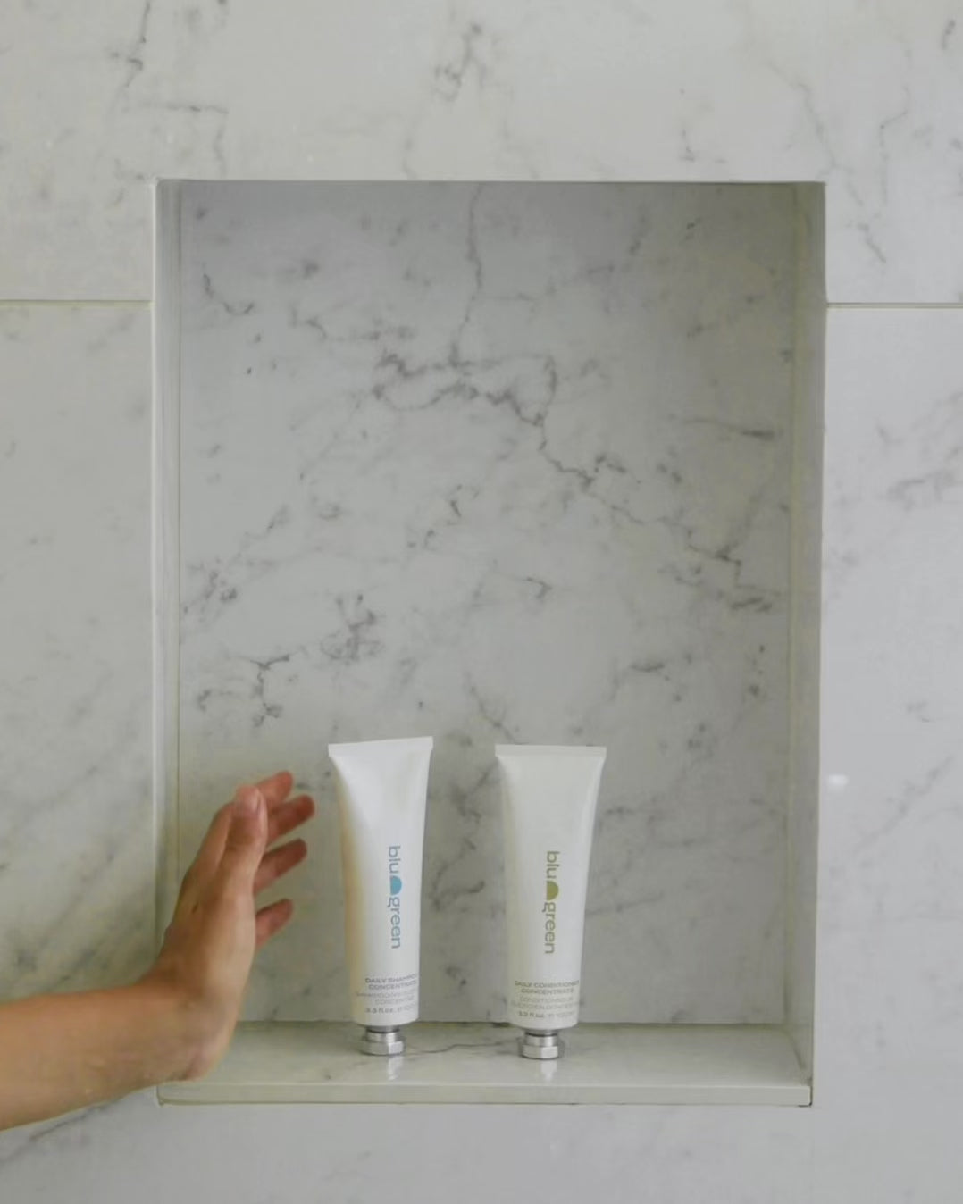 Woman in shower washing hair using Blu & Green's Daily Shampoo & Conditioner Concentrates.